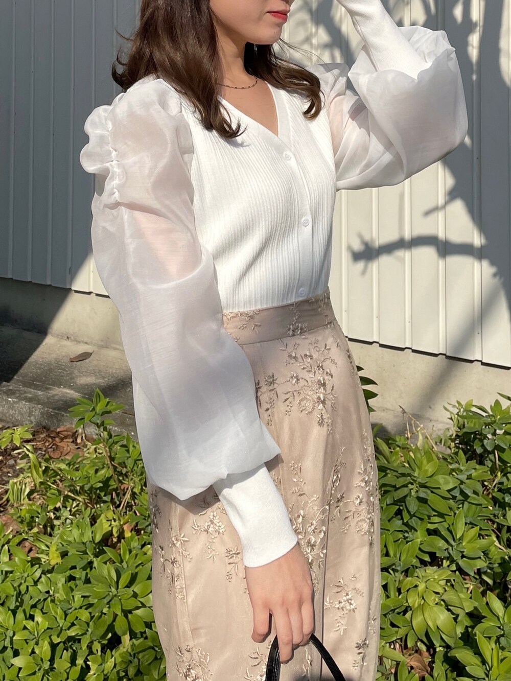 ホワイト系のカーディガン/ボレロ、ブラウン系のスカートを着用したレディースの冬コーディネートの3枚目の写真