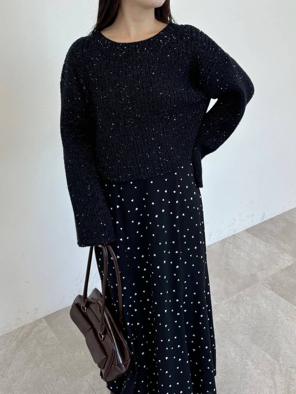 ブラウン系のブーツ、ブラウン系のハンドバッグ、ブラック系のスカートを着用したレディースの冬コーディネートの3枚目の写真