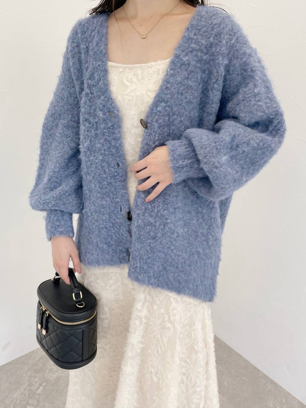 ブルー系のカーディガン/ボレロ、ブラック系のショルダーバッグ、ホワイト系のワンピースを着用したレディースの秋コーディネートの4枚目の写真