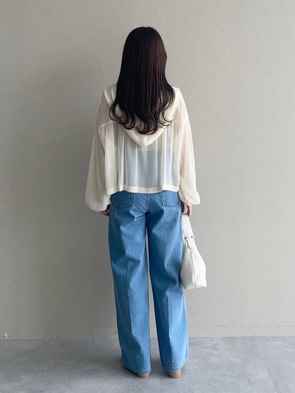 ホワイト系のパーカー、ブルー系のデニムパンツ、ブラウン系のパンプスを着用したレディースの夏コーディネートの2枚目の写真