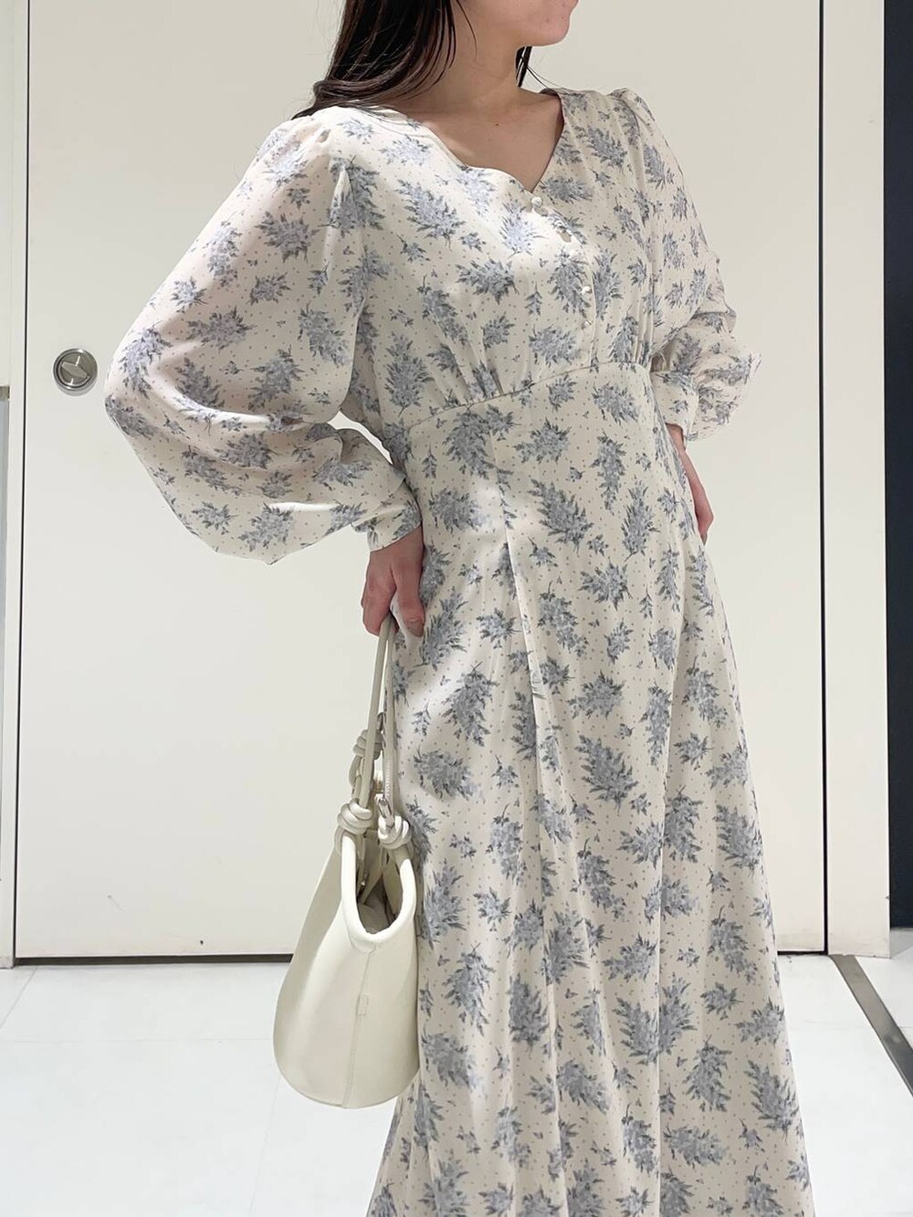 ブルー系のワンピース、ホワイト系のブーツ、ホワイト系のハンドバッグを着用したレディースの春コーディネートの3枚目の写真