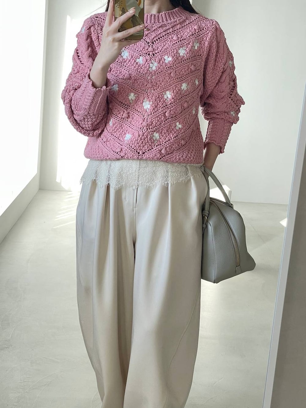 ベージュ系のハンドバッグ、ピンク系のニット/セーター、ホワイト系のシャツ/ブラウスを着用したレディースの冬コーディネートの3枚目の写真