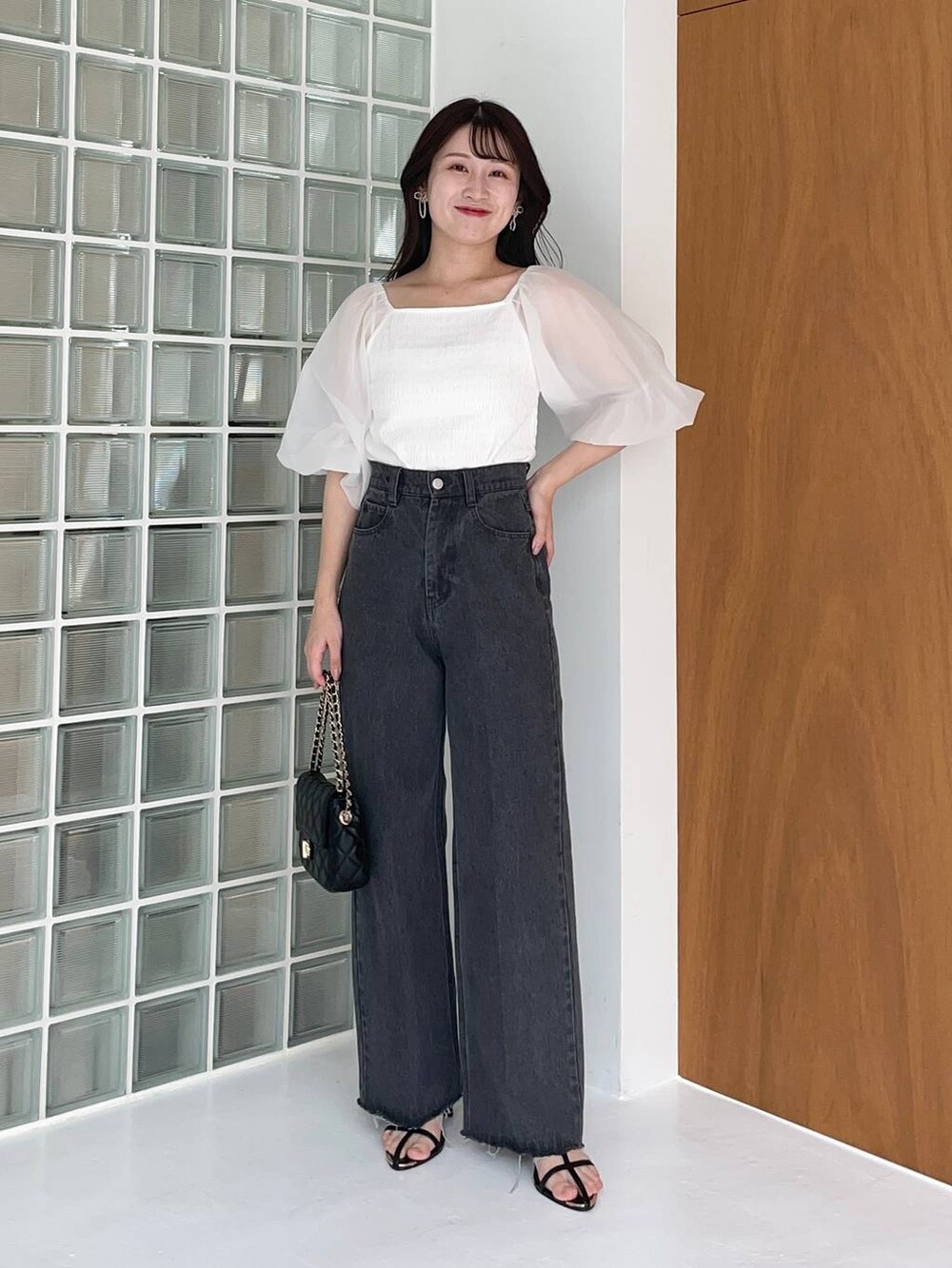 ホワイト系のTシャツ/カットソー、ブラック系のデニムパンツ、ブラック系のショルダーバッグを着用したレディースの夏コーディネートの2枚目の写真
