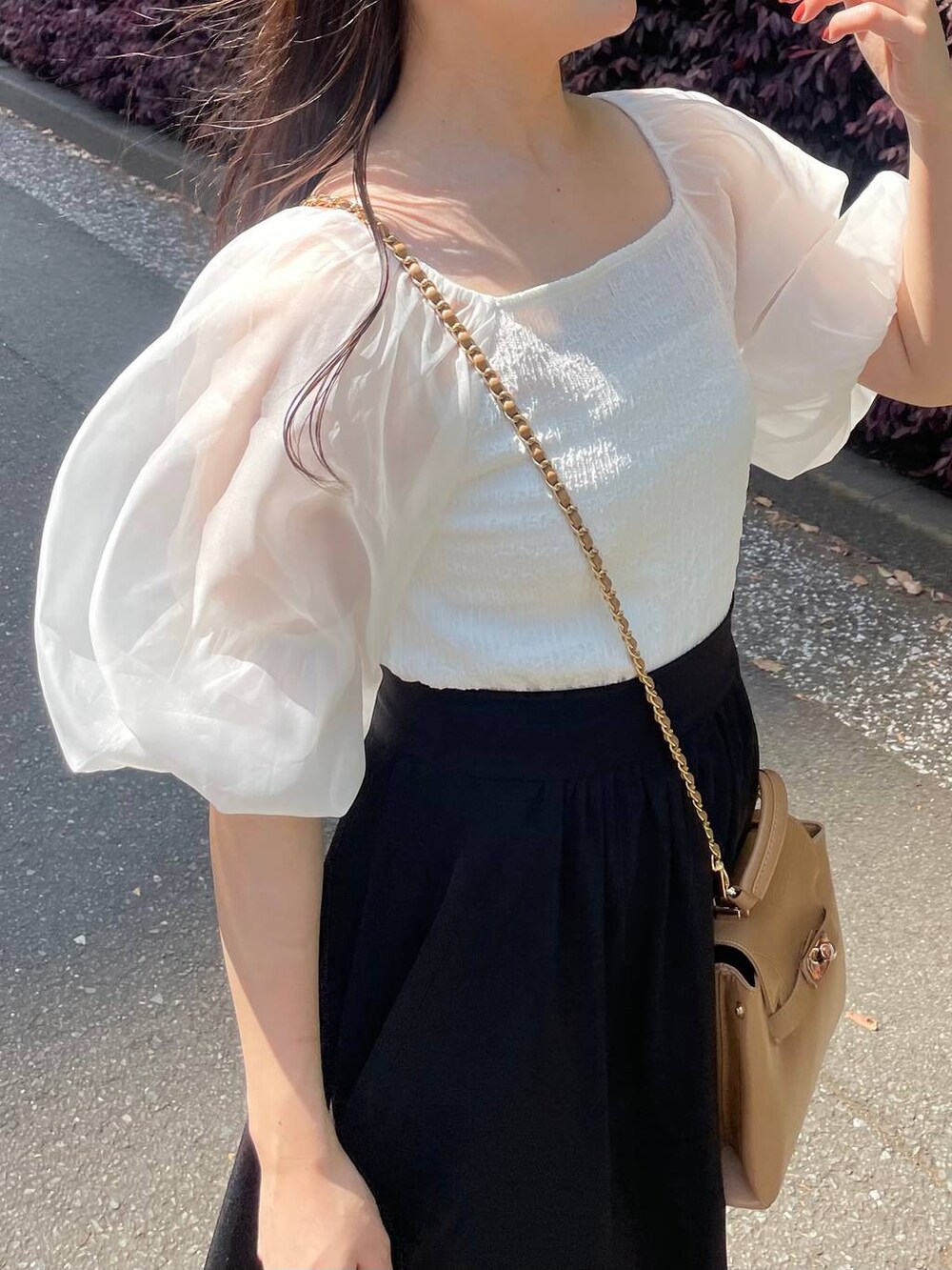 ホワイト系のTシャツ/カットソー、ブラック系のスカート、ブラウン系のショルダーバッグを着用したレディースの春コーディネートの4枚目の写真