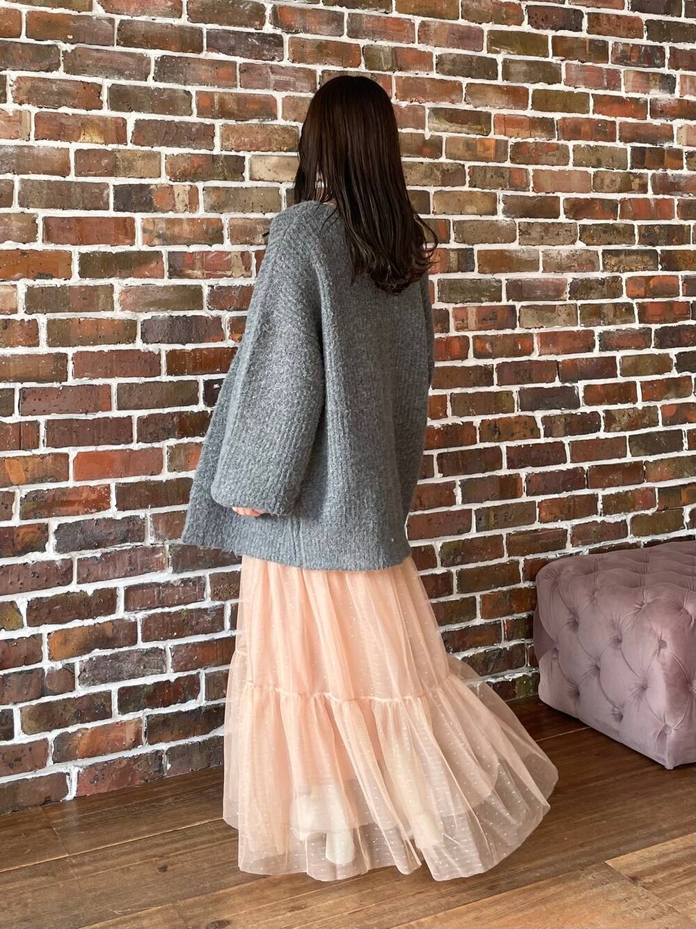 ホワイト系のブーツ、グレー系のカーディガン/ボレロ、ホワイト系のハンドバッグを着用したレディースの秋コーディネートの2枚目の写真