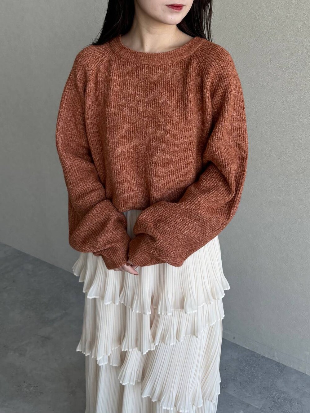 ベージュ系のピーコート、ブラウン系のブーツ、オレンジ系のニット/セーターを着用したレディースの冬コーディネートの5枚目の写真