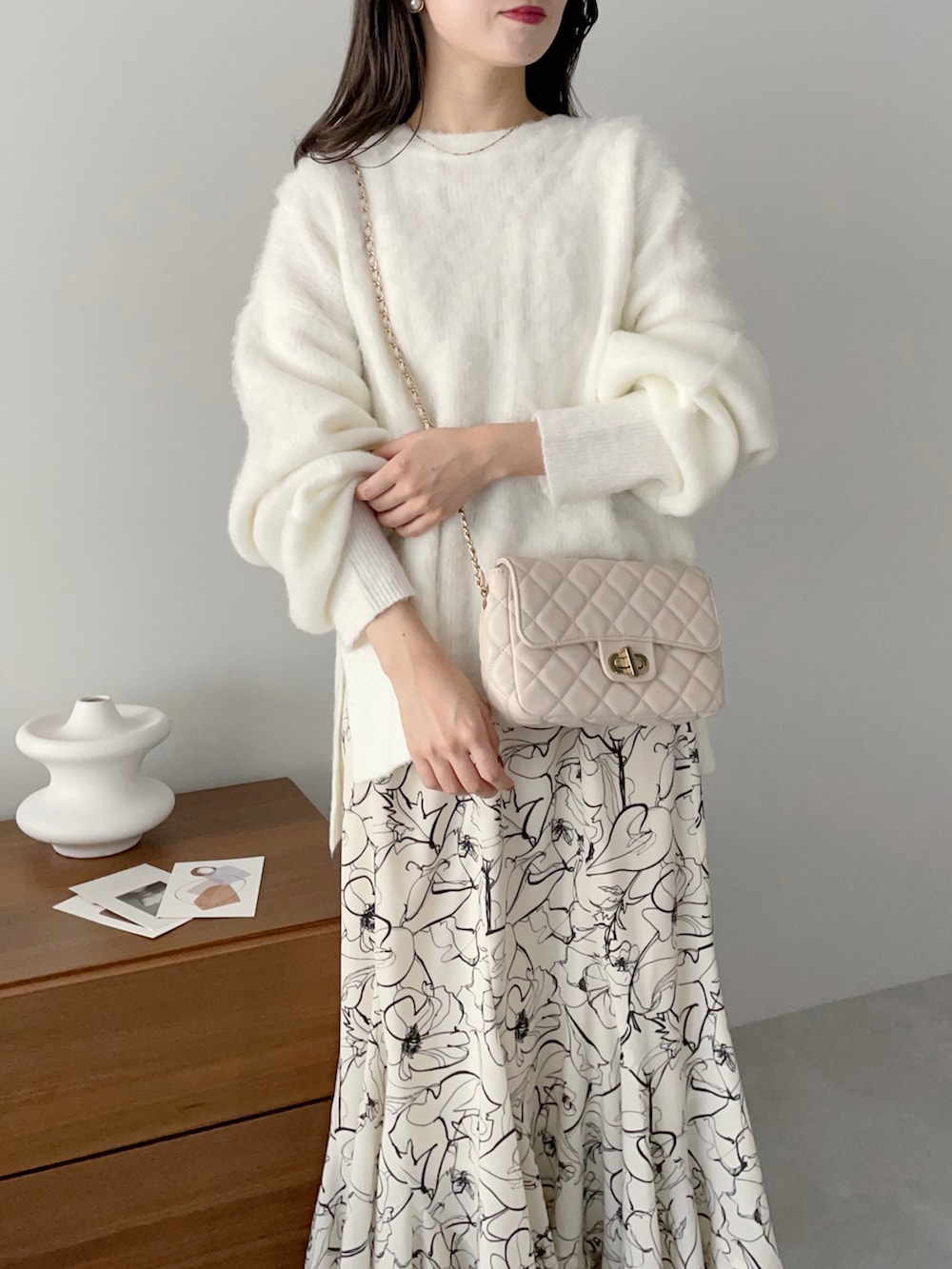 ホワイト系のニット/セーター、ホワイト系のショルダーバッグ、ホワイト系のスカートを着用したレディースの秋コーディネートの3枚目の写真