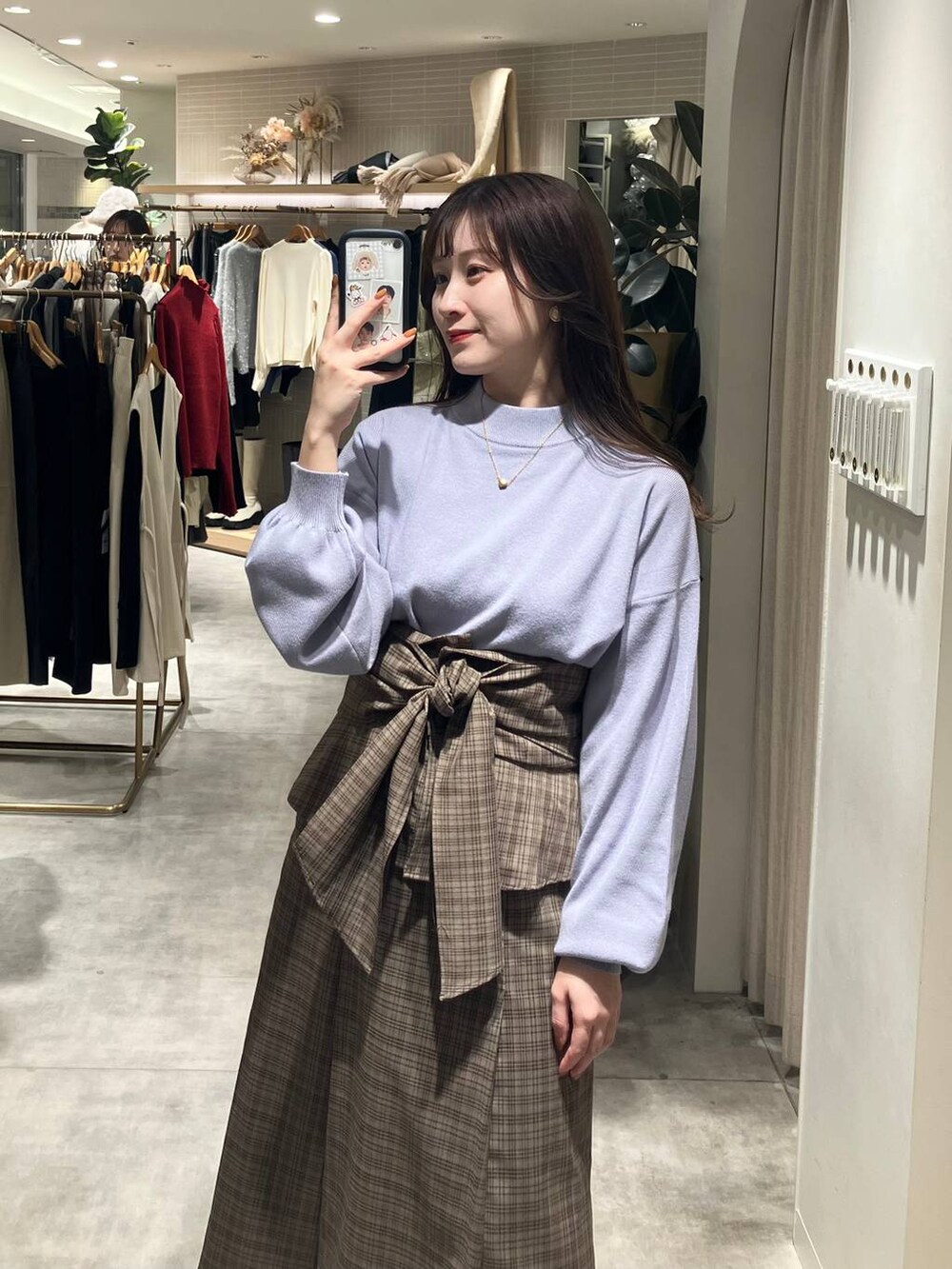 ホワイト系のブーツ、ブラウン系のスカート、ブルー系のニット/セーターを着用したレディースの秋コーディネートの2枚目の写真