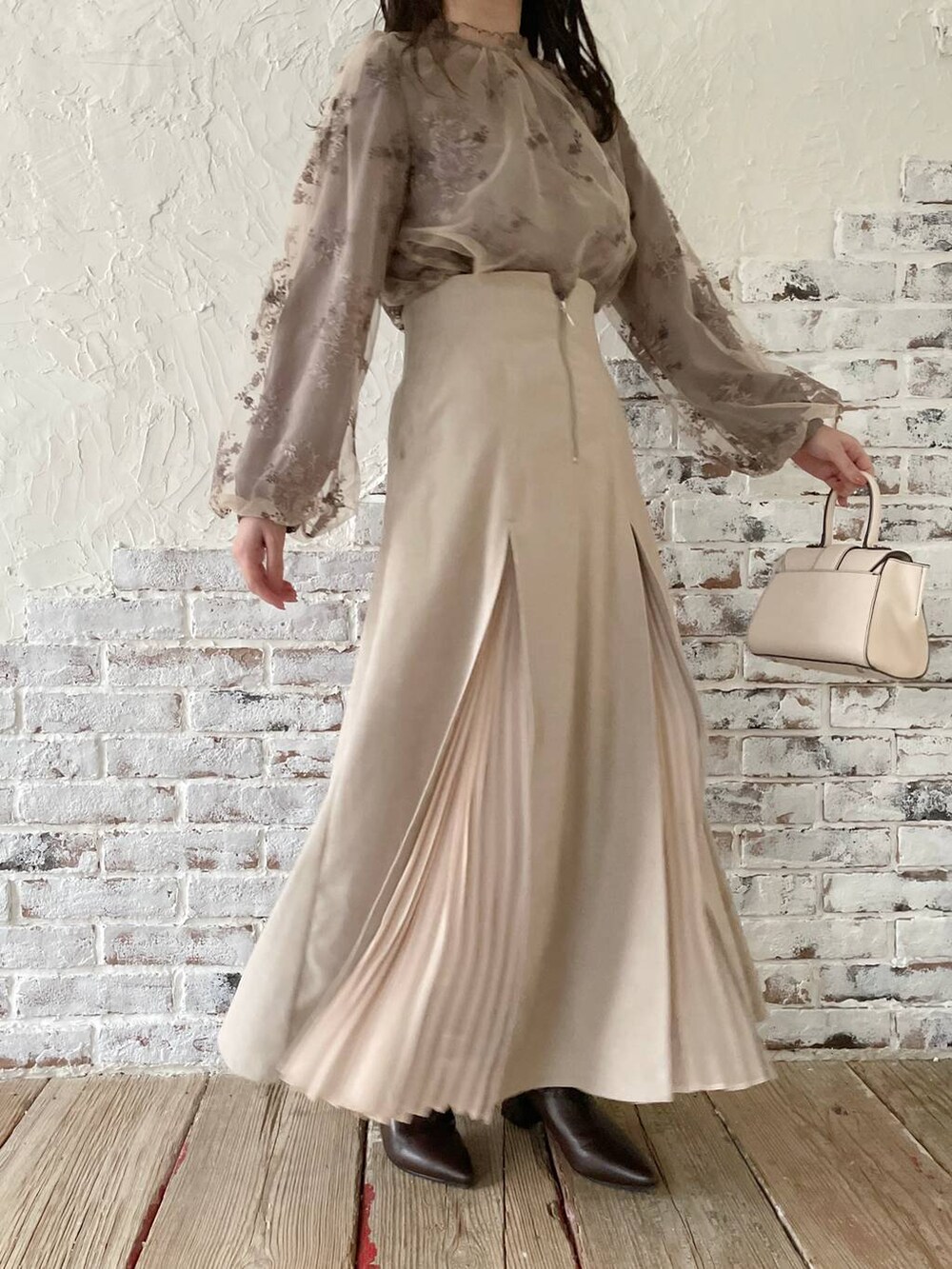 ホワイト系のハンドバッグ、ブラウン系のシャツ/ブラウス、ブラウン系のブーツを着用したレディースの秋コーディネートの4枚目の写真