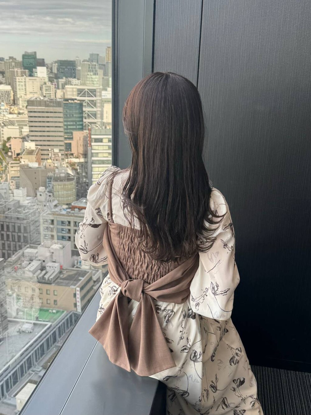 ホワイト系のショルダーバッグ、ホワイト系のワンピース、ホワイト系のブーツを着用したレディースの冬コーディネートの5枚目の写真