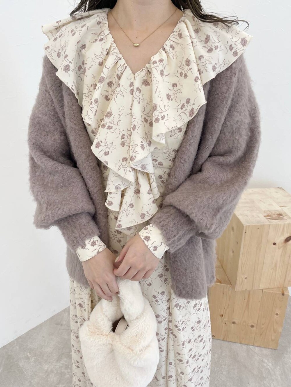 ブラウン系のカーディガン/ボレロ、ホワイト系のハンドバッグ、ブラウン系のブーツを着用したレディースの秋コーディネートの3枚目の写真