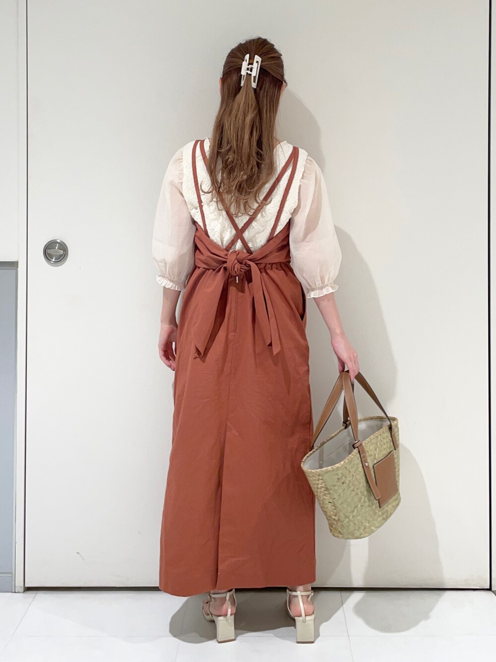 ホワイト系のTシャツ/カットソー、オレンジ系のワンピース、ベージュ系のハンドバッグを着用したレディースの春コーディネートの2枚目の写真