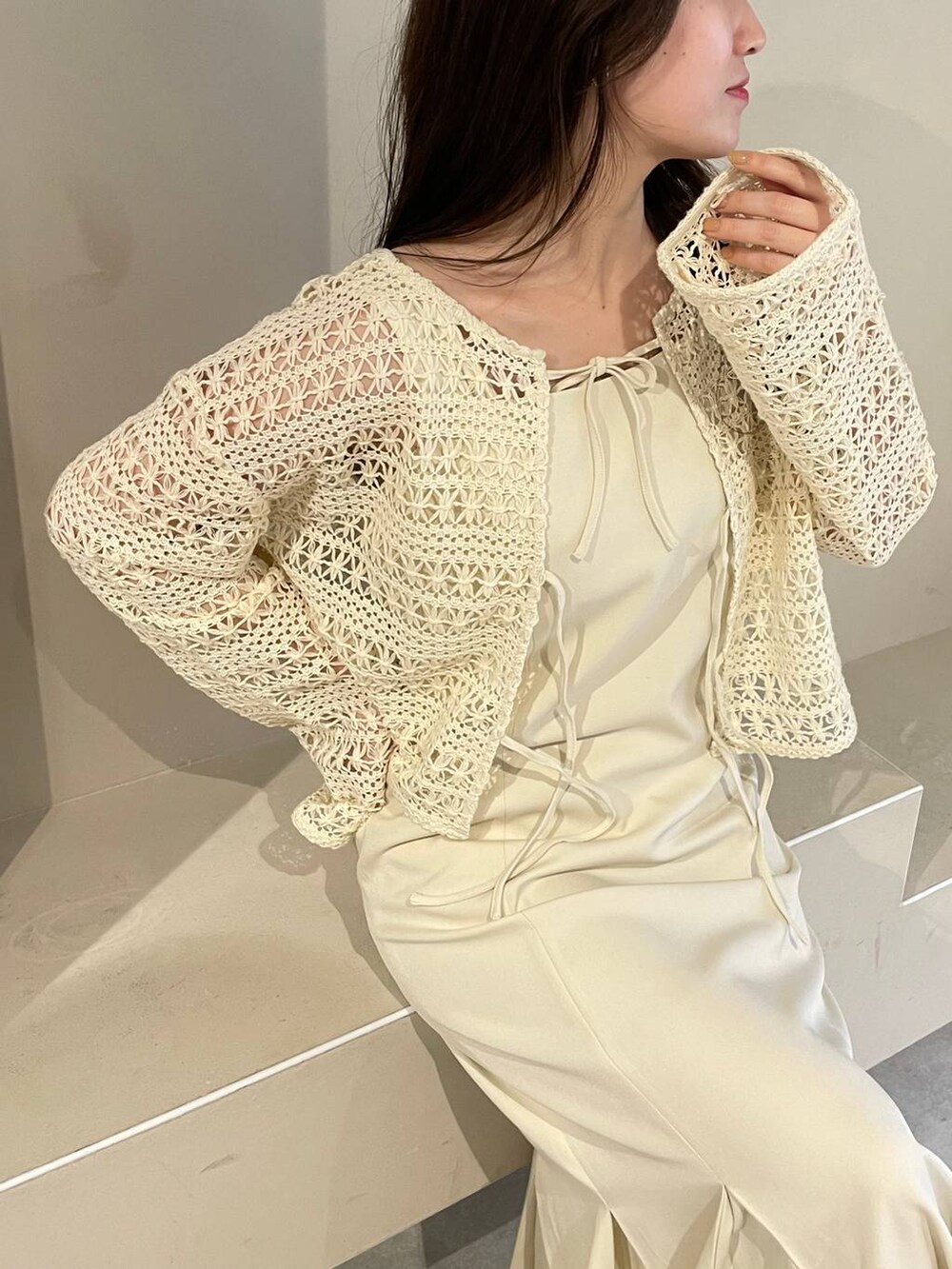 ホワイト系のハンドバッグ、ホワイト系のカーディガン/ボレロ、ホワイト系のサンダルを着用したレディースの春コーディネートの4枚目の写真