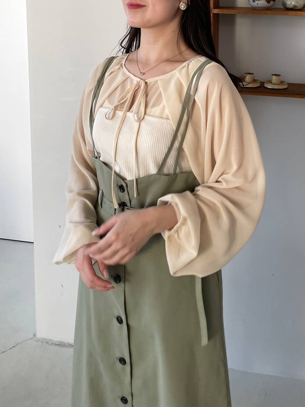 グリーン系のスカート、ブラック系のパンプス、ホワイト系のTシャツ/カットソーを着用したレディースの冬コーディネートの2枚目の写真