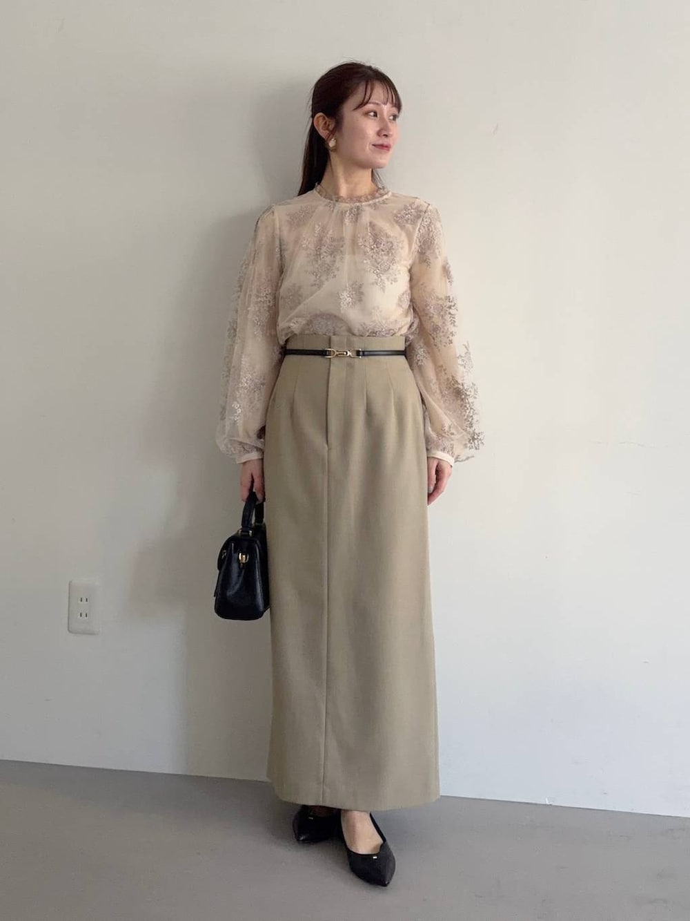 ブラック系のショルダーバッグ、ベージュ系のテーラードジャケット、ベージュ系のスカートを着用したレディースの冬コーディネートの3枚目の写真