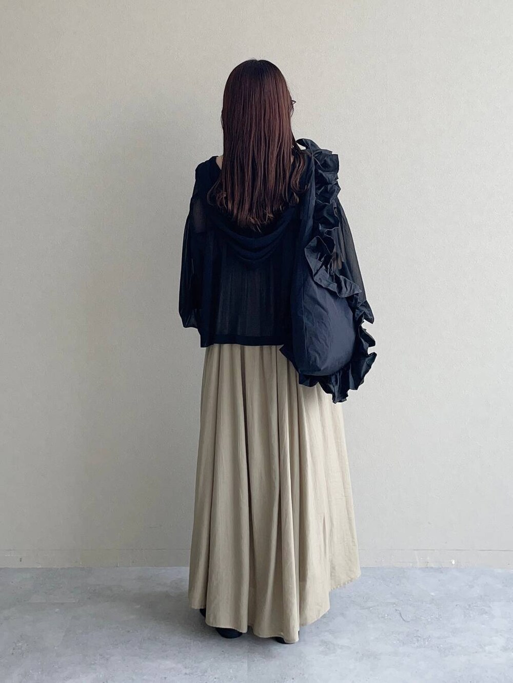 ブラック系のサンダル、ブラック系のパーカー、ベージュ系のワンピースを着用したレディースの春コーディネートの2枚目の写真