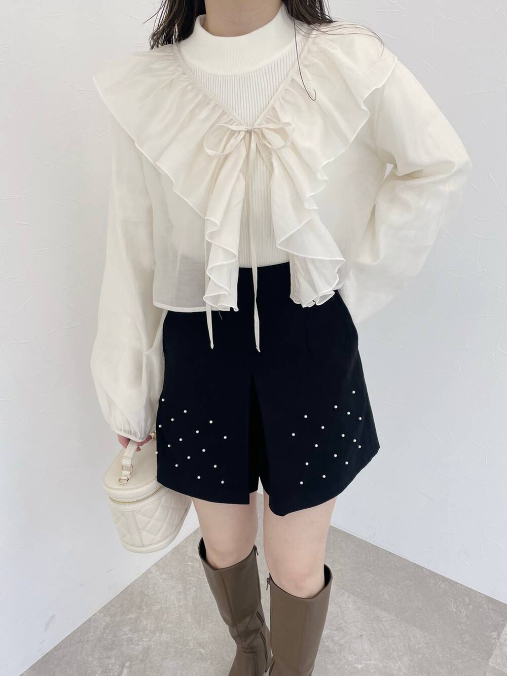 ホワイト系のショルダーバッグ、ブラック系のその他パンツ、ホワイト系のシャツ/ブラウスを着用したレディースの秋コーディネートの3枚目の写真