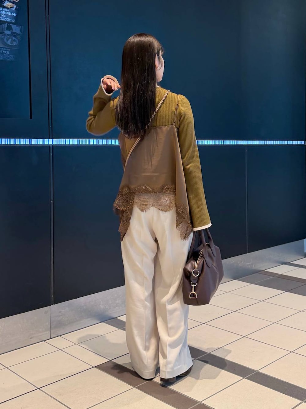 ブラウン系のボストンバッグ、ホワイト系のスラックス、ブラウン系のニット/セーターを着用したレディースの春コーディネートの2枚目の写真