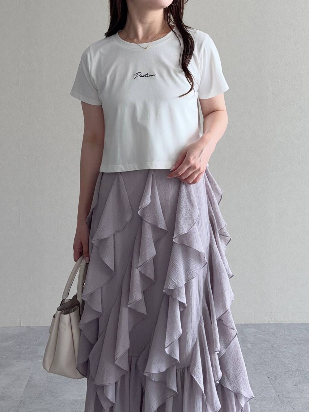 ホワイト系のTシャツ/カットソー、グレー系のスカート、ホワイト系のショルダーバッグを着用したレディースの秋コーディネートの3枚目の写真
