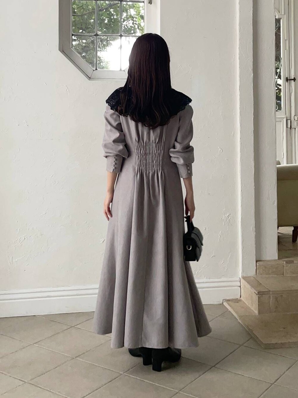 ブラック系のブーツ、ブラック系のショルダーバッグ、グレー系のワンピースを着用したレディースの冬コーディネートの3枚目の写真