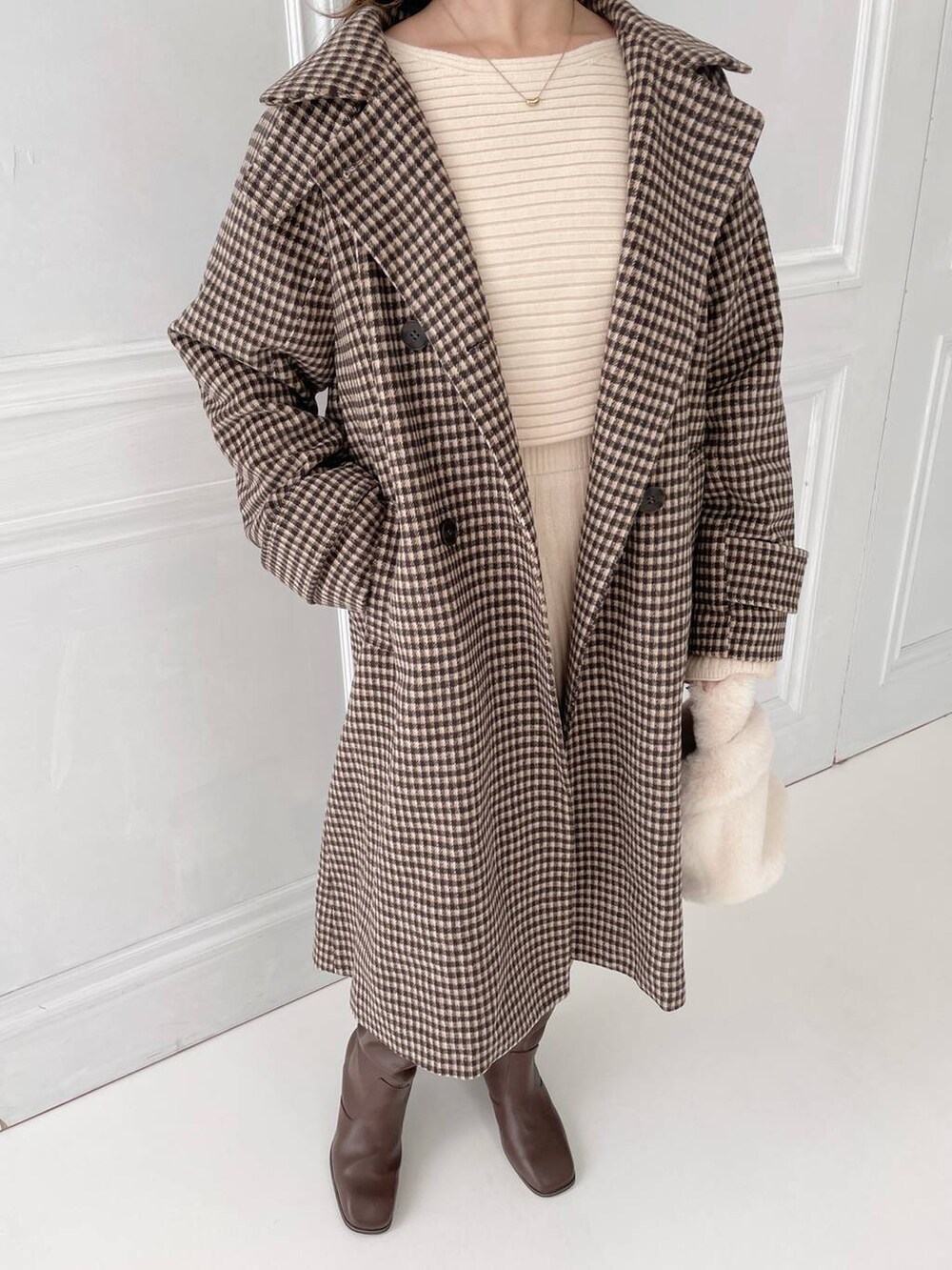 ブラウン系のブーツ、ホワイト系のハンドバッグ、ホワイト系のワンピースを着用したレディースの秋コーディネートの3枚目の写真