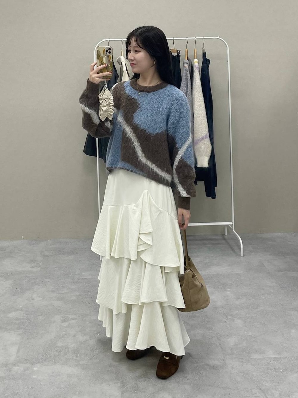 ブラウン系のニット/セーター、ホワイト系のスカート、ブラック系のローファーを着用したレディースの秋コーディネートの3枚目の写真