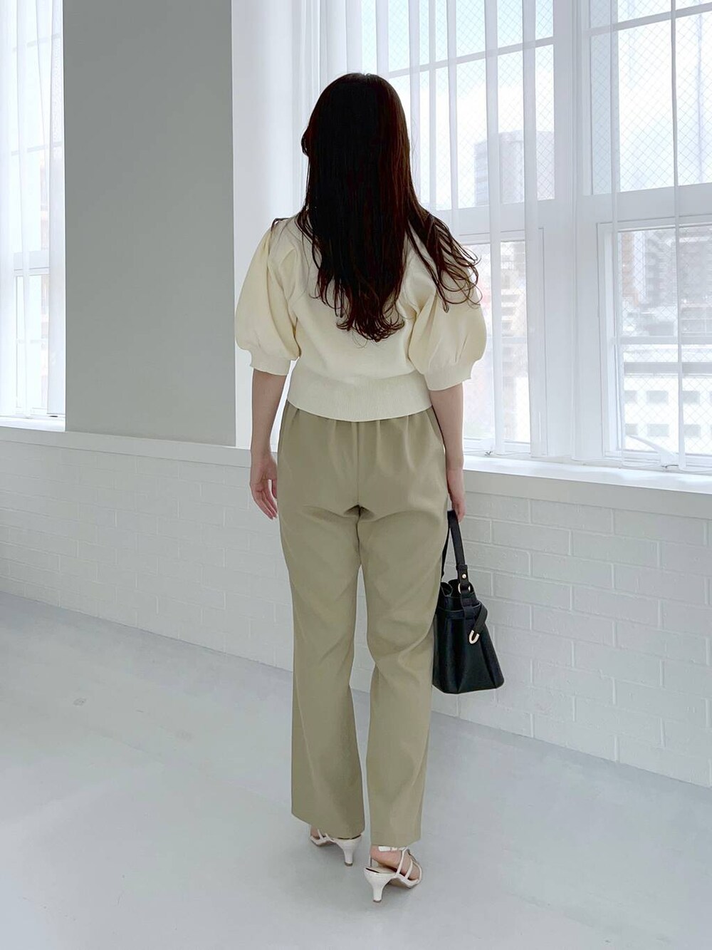 ブラック系のショルダーバッグ、ホワイト系のサンダル、ホワイト系のカーディガン/ボレロを着用したレディースの夏コーディネートの2枚目の写真