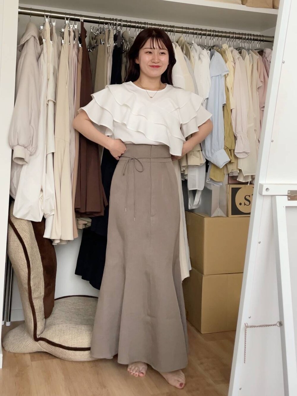 ベージュ系のテーラードジャケット、ホワイト系のシャツ/ブラウス、ベージュ系のスカートを着用したレディースの夏コーディネートの2枚目の写真