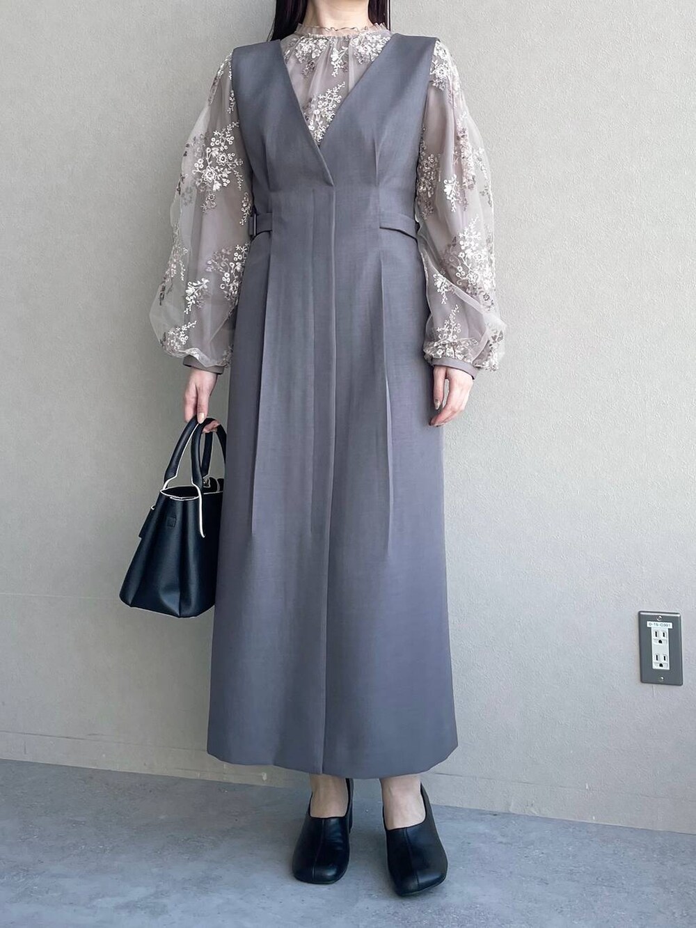 ブラウン系のシャツ/ブラウス、ブラック系のショルダーバッグ、グレー系のジャンパースカートを着用したレディースの冬コーディネートの4枚目の写真