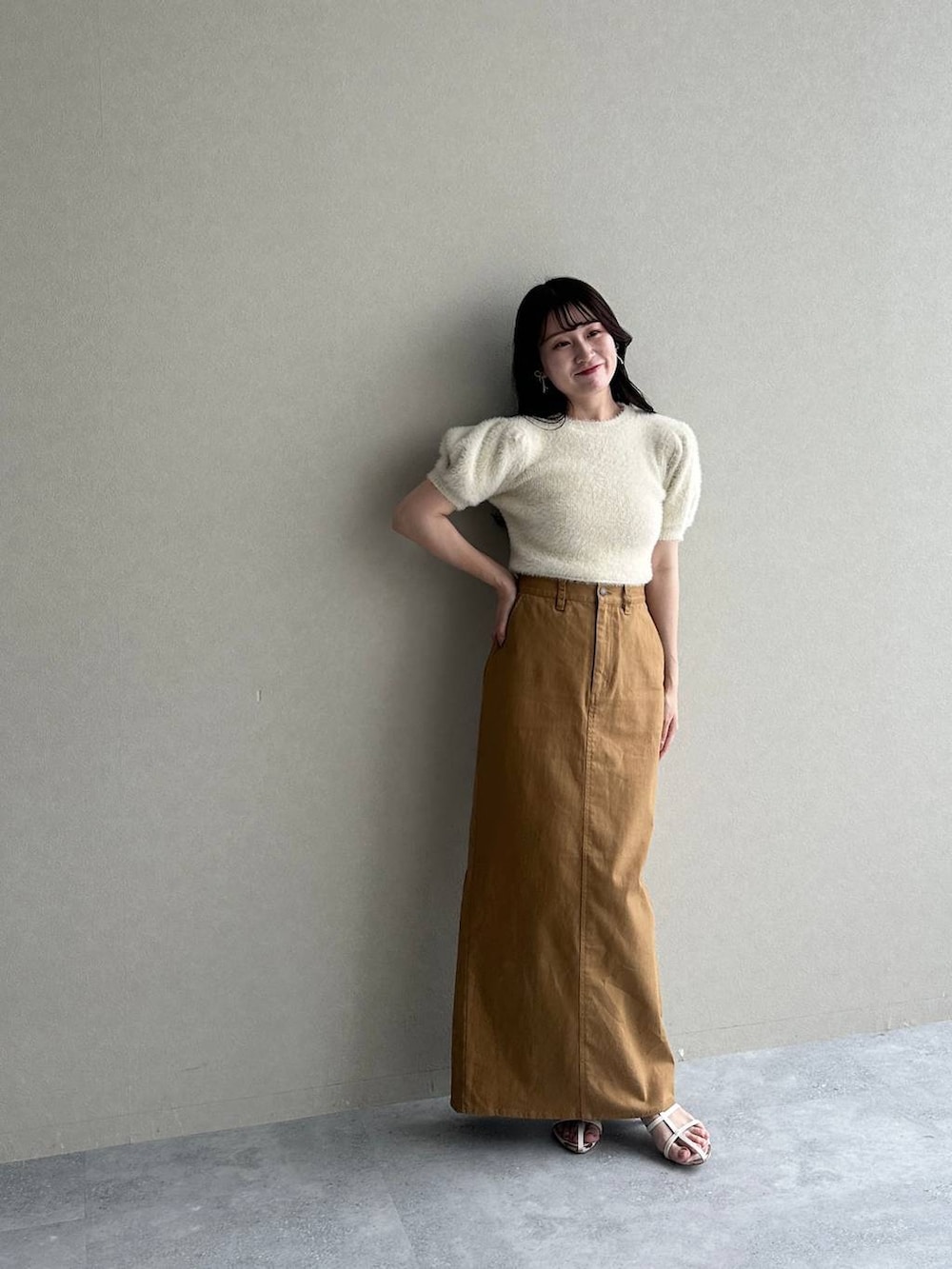 ベージュ系のニット/セーター、ホワイト系のサンダル、ブラウン系のスカートを着用したレディースの夏コーディネートの4枚目の写真