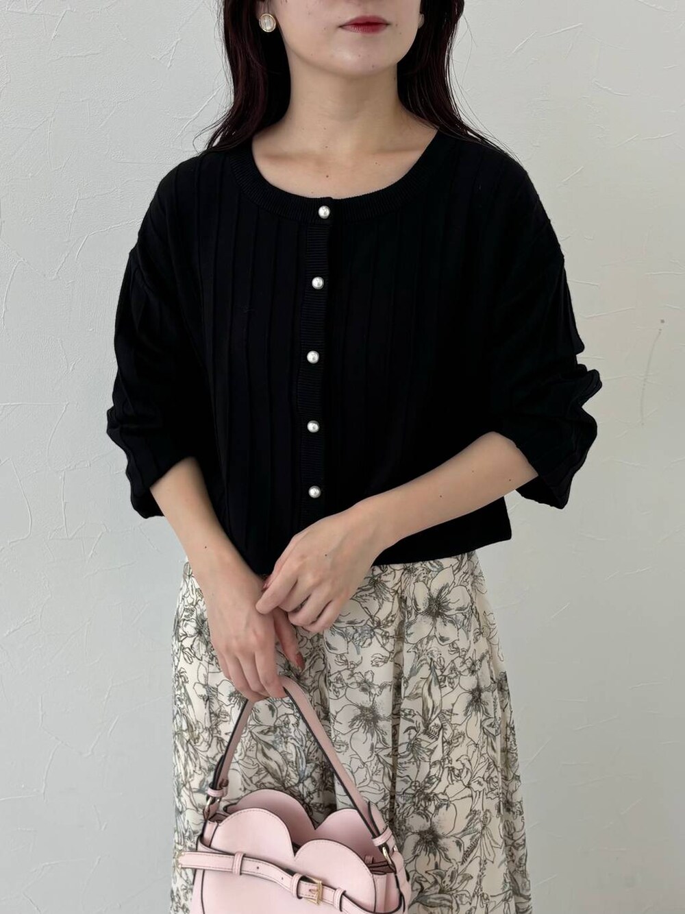 ベージュ系のピーコート、ピンク系のショルダーバッグ、ホワイト系のスカートを着用したレディースの秋コーディネートの6枚目の写真