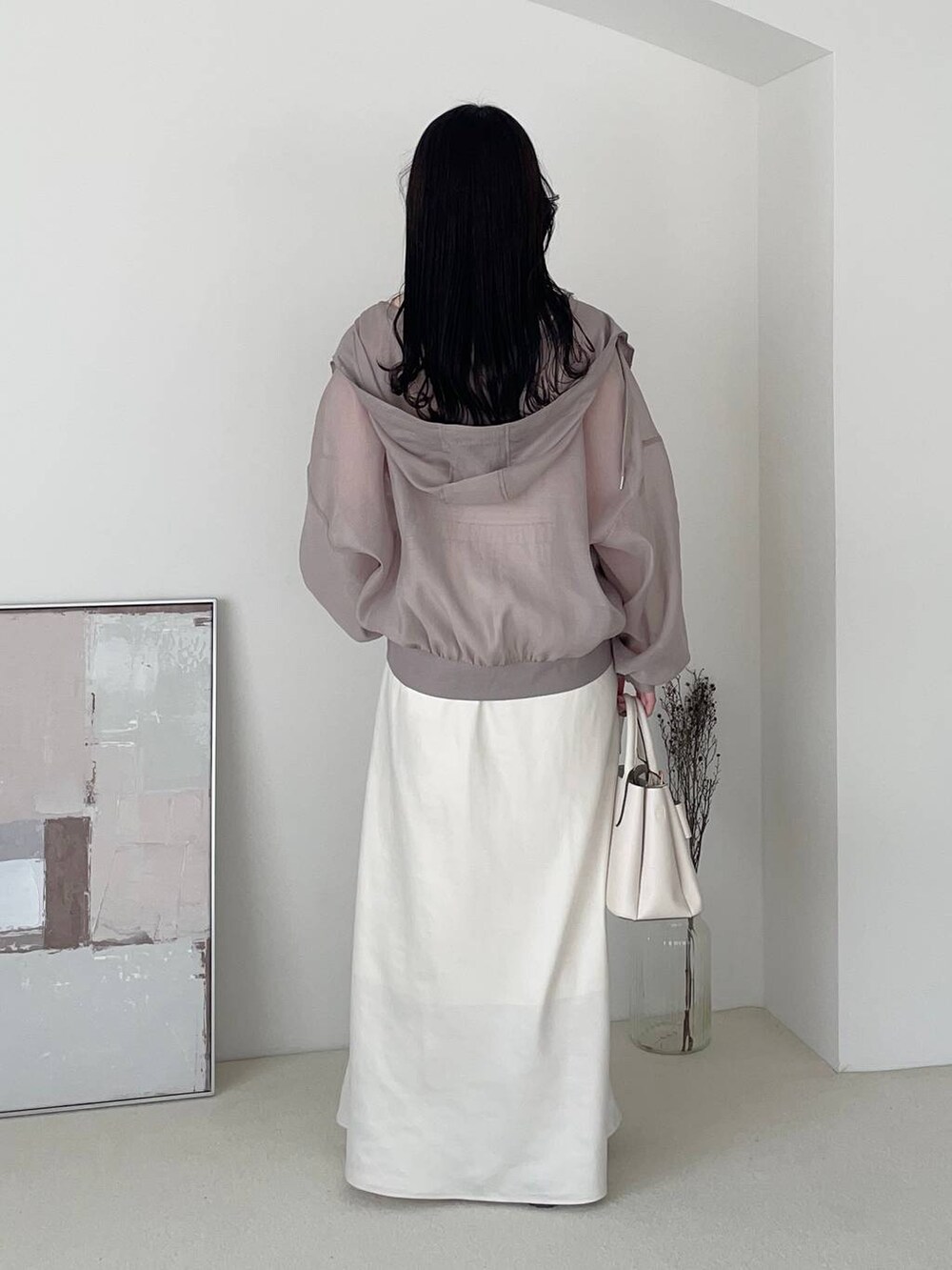 ホワイト系のショルダーバッグ、ブラウン系のブルゾン、ブラック系のバレエシューズを着用したレディースの春コーディネートの2枚目の写真