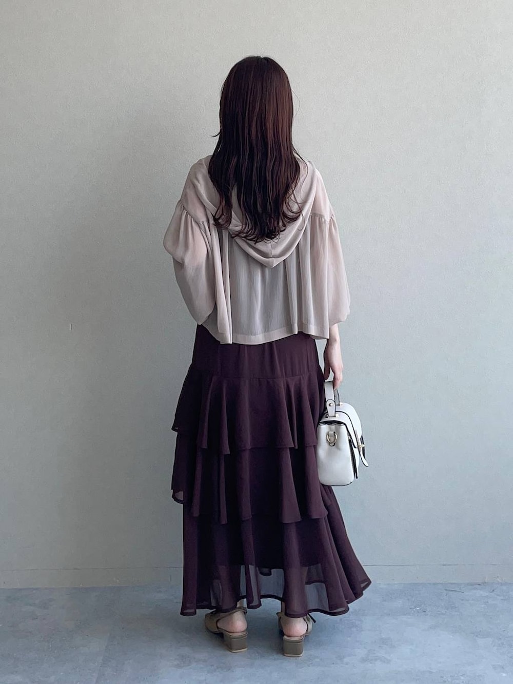 ベージュ系のパーカー、ブラウン系のサンダル、ホワイト系のショルダーバッグを着用したレディースの夏コーディネートの2枚目の写真