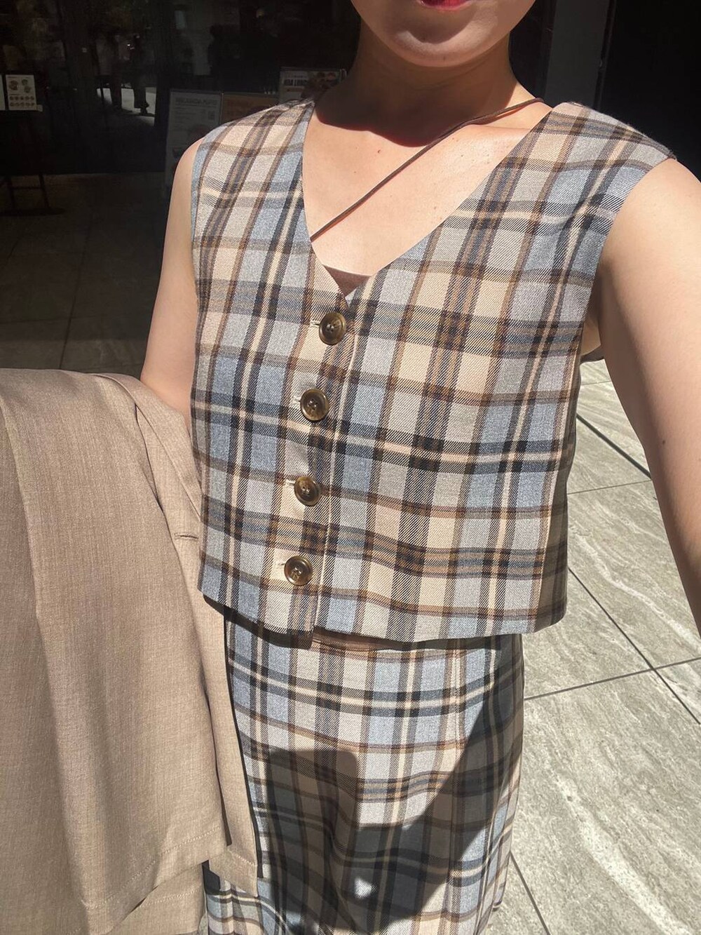 ベージュ系のテーラードジャケット、ブラウン系のショルダーバッグ、ベージュ系のワンピースを着用したレディースの秋コーディネートの4枚目の写真