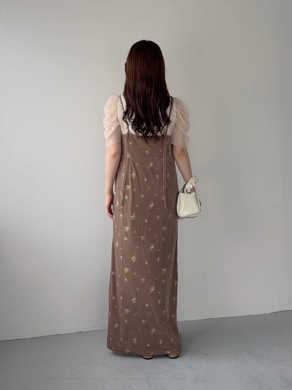 ベージュ系のサンダル、ベージュ系のワンピース、ホワイト系のTシャツ/カットソーを着用したレディースの夏コーディネートの2枚目の写真