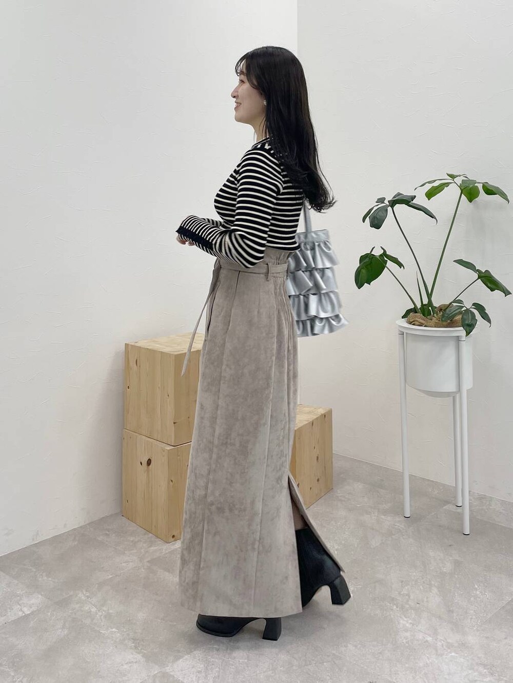 ブラウン系のスカート、グレー系のブーツ、ブラック系のニット/セーターを着用したレディースの冬コーディネートの3枚目の写真