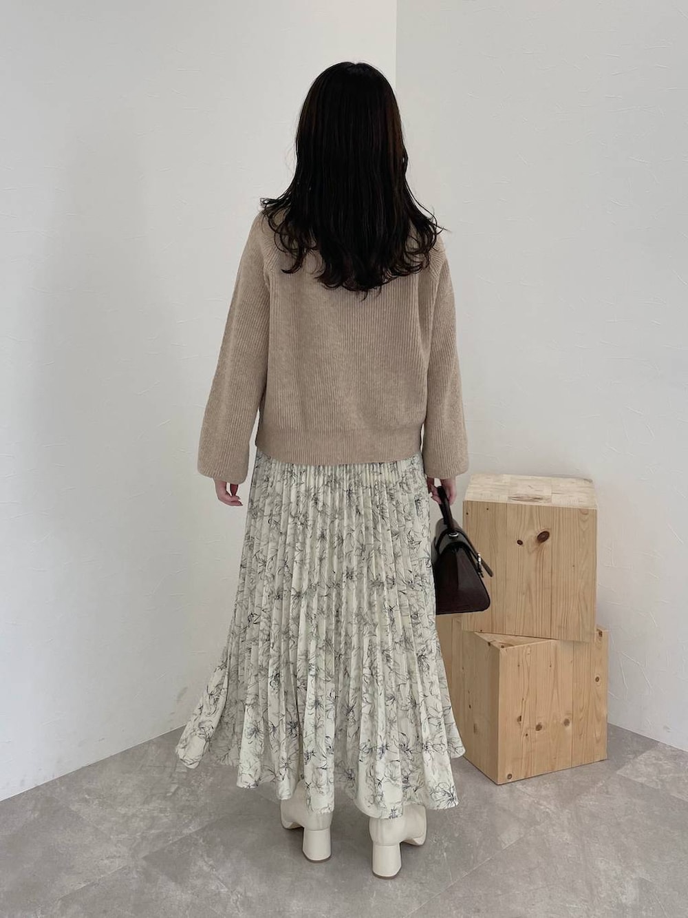 ベージュ系のニット/セーター、ブラウン系のチェスターコート、ブラウン系のハンドバッグを着用したレディースの秋コーディネートの5枚目の写真