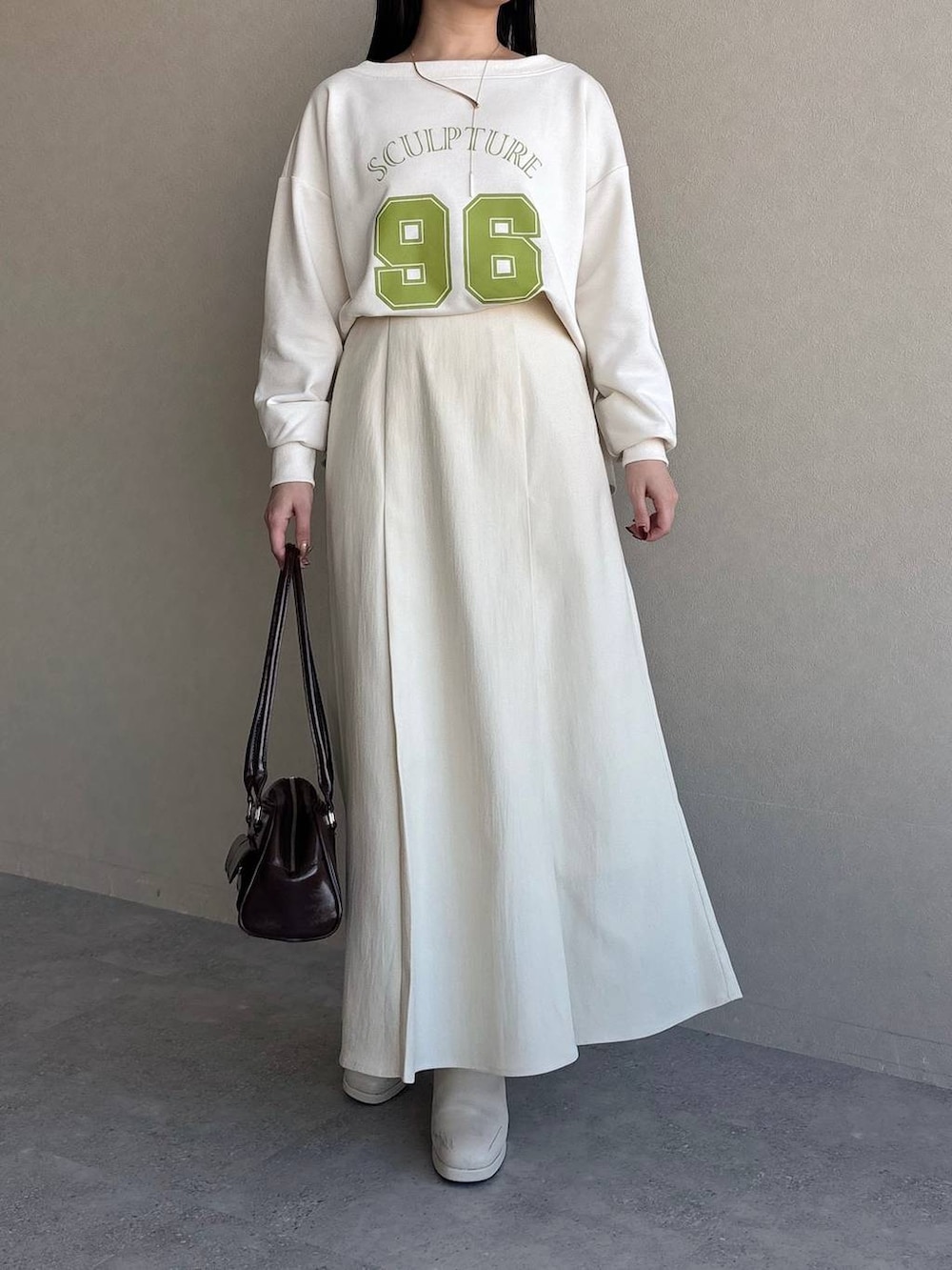 ホワイト系のブーツ、ブラウン系のハンドバッグ、ホワイト系のスウェットを着用したレディースの冬コーディネートの4枚目の写真