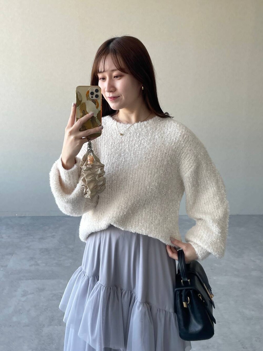 ブラック系のローファー、ブラック系のショルダーバッグ、ホワイト系のニット/セーターを着用したレディースの冬コーディネートの3枚目の写真