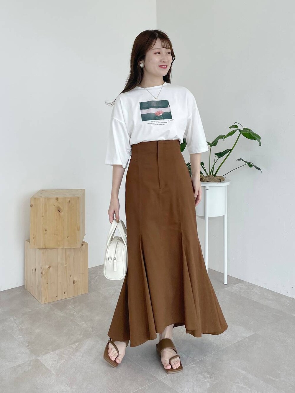 ブラウン系のサンダル、ホワイト系のTシャツ/カットソー、ホワイト系のボストンバッグを着用したレディースの夏コーディネートの2枚目の写真