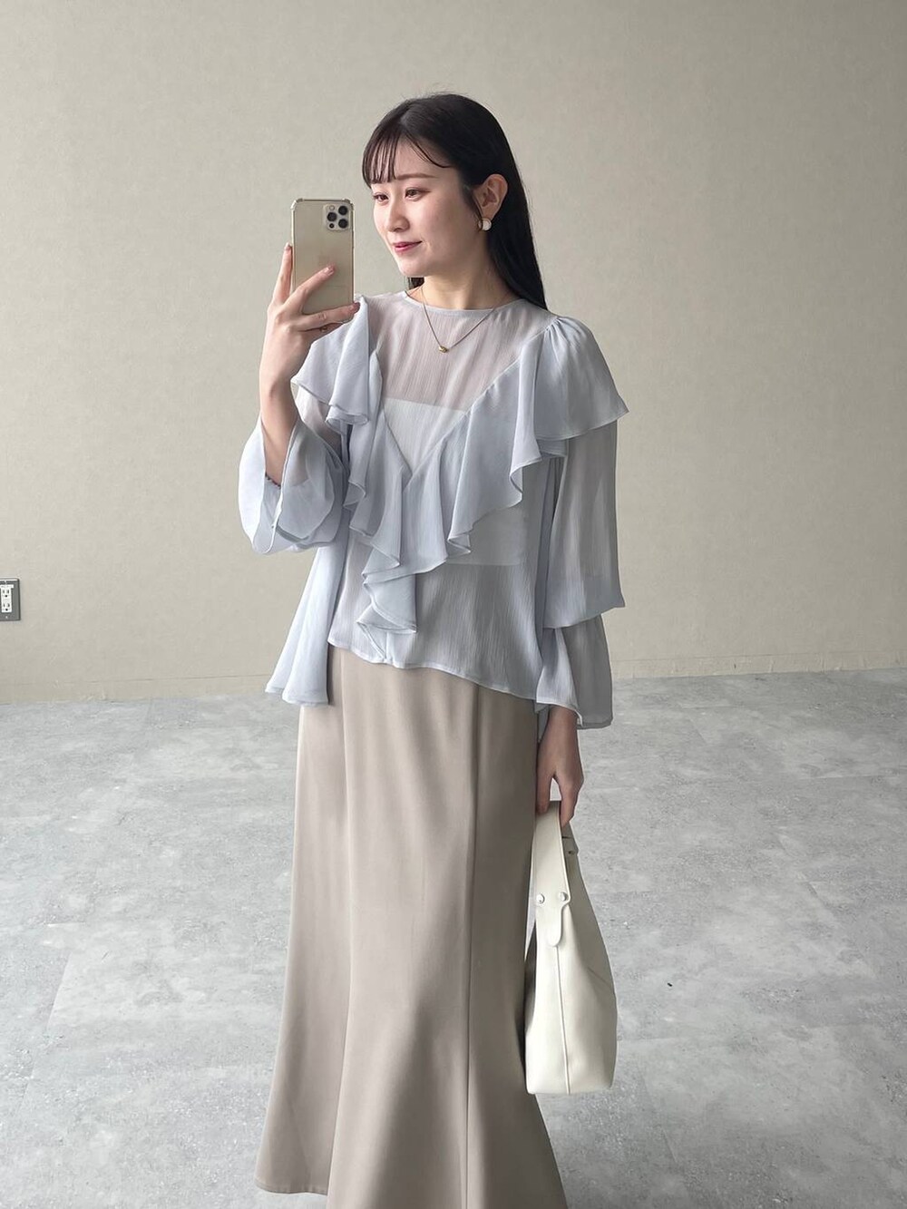 シルバー系のバレエシューズ、ホワイト系のショルダーバッグ、ゴールド系のネックレスを着用したレディースの春コーディネートの3枚目の写真