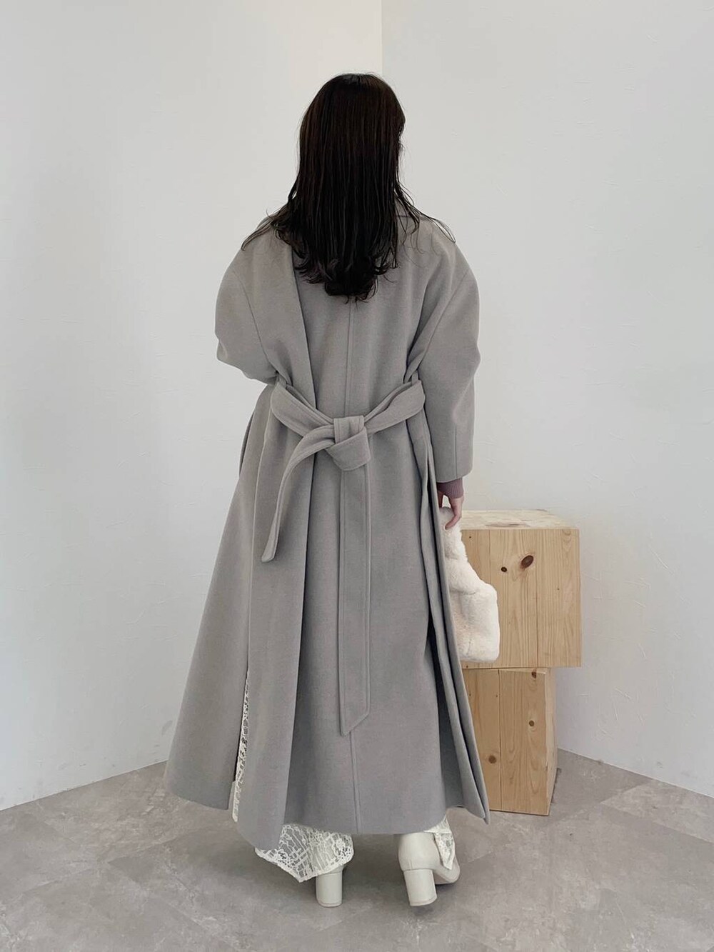 ホワイト系のブーツ、ホワイト系のスカート、ホワイト系のハンドバッグを着用したレディースの秋コーディネートの2枚目の写真