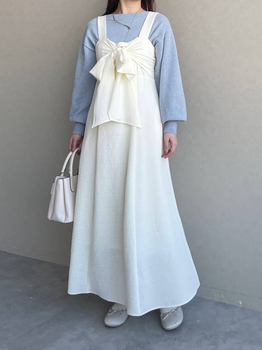 ブルー系のニット/セーター、ホワイト系のショルダーバッグ、シルバー系のバレエシューズを着用したレディースの春コーディネートの5枚目の写真