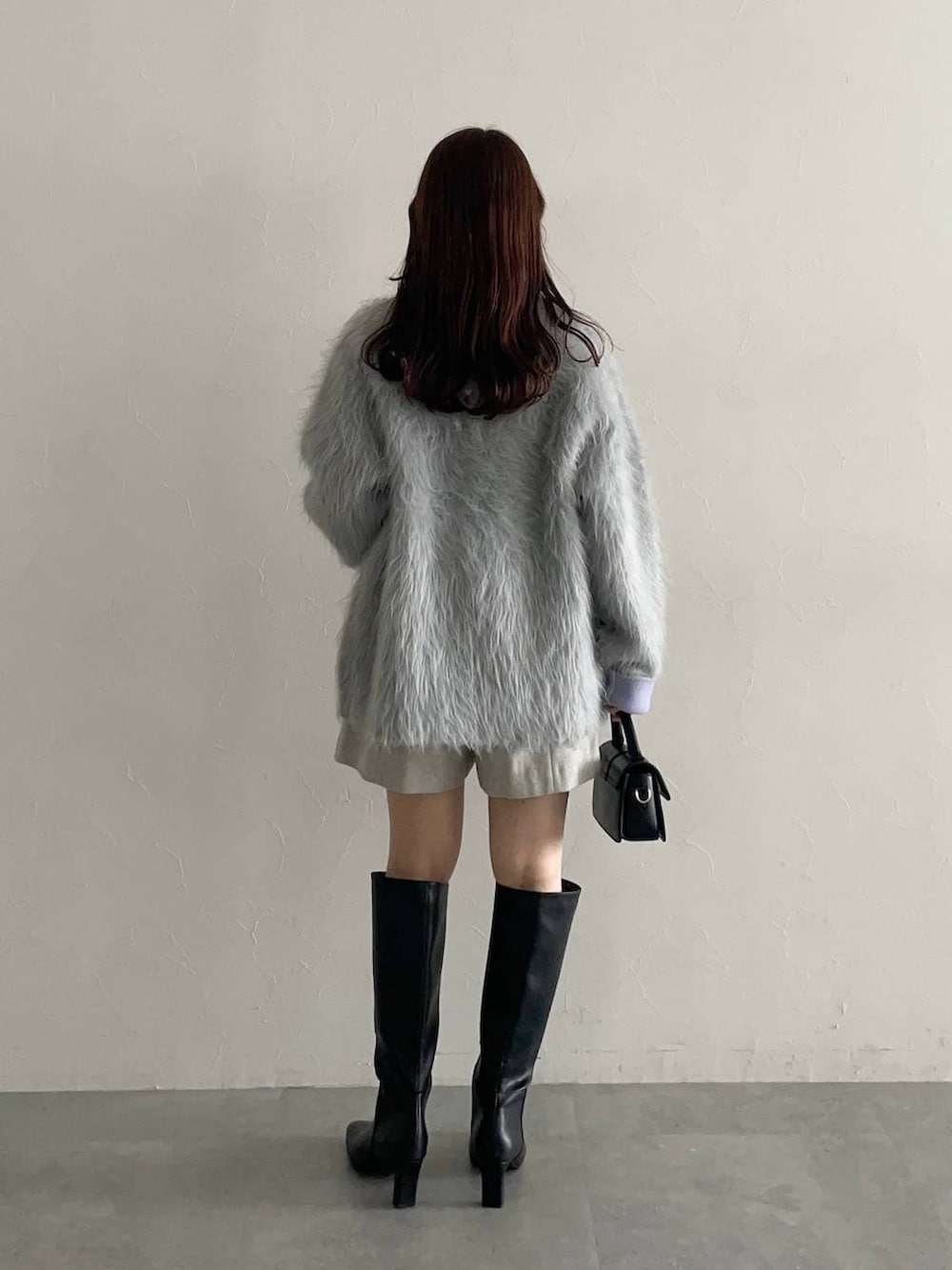 ホワイト系のニット/セーター、グレー系のカーディガン/ボレロ、グレー系のその他パンツを着用したレディースの秋コーディネートの2枚目の写真