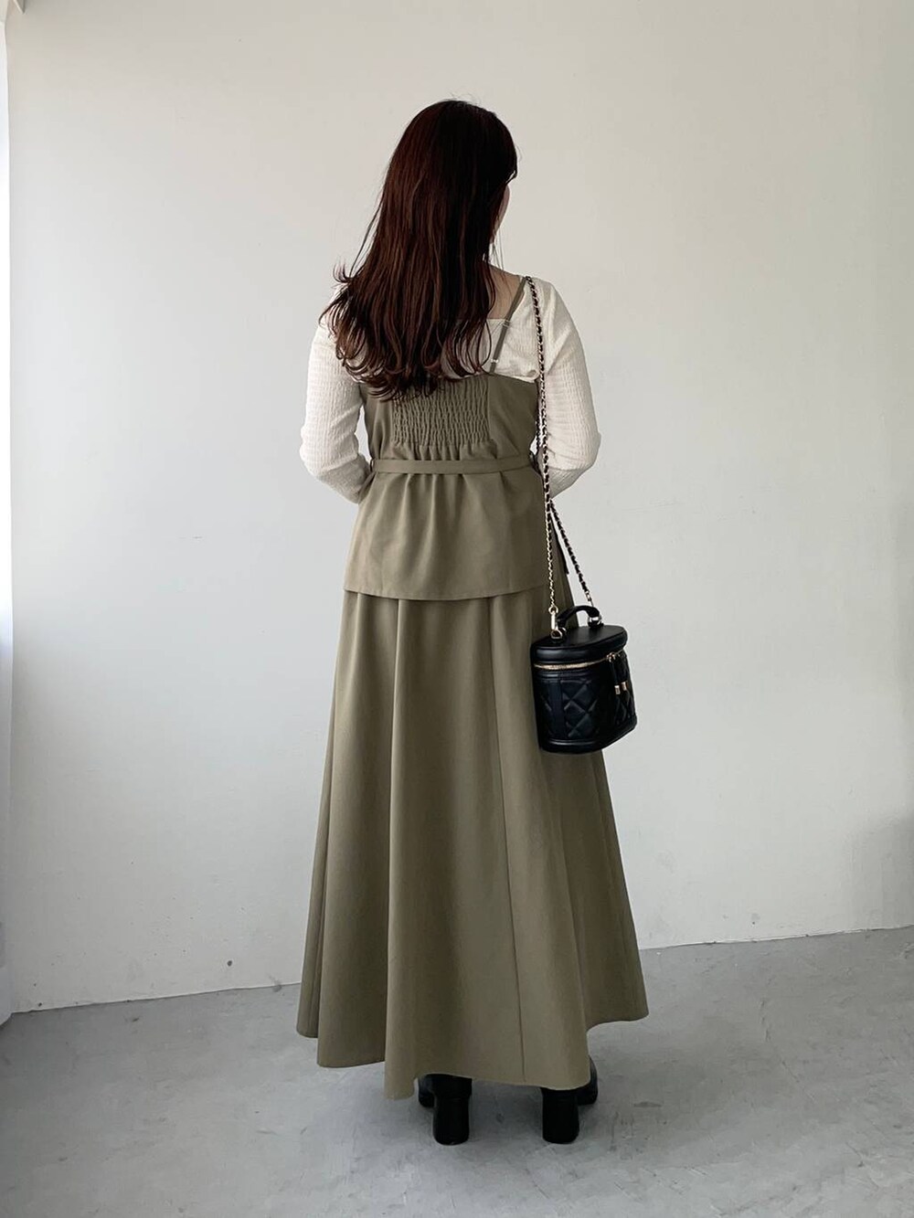 ブラウン系のワンピース、ブラック系のブーツ、ホワイト系のTシャツ/カットソーを着用したレディースの秋コーディネートの2枚目の写真