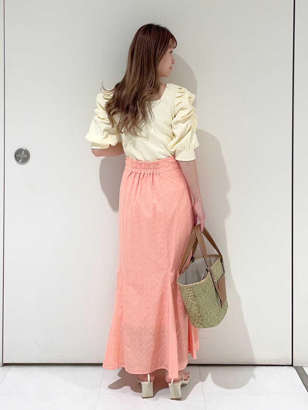 ホワイト系のTシャツ/カットソー、ピンク系のスカート、ベージュ系のハンドバッグを着用したレディースの春コーディネートの2枚目の写真