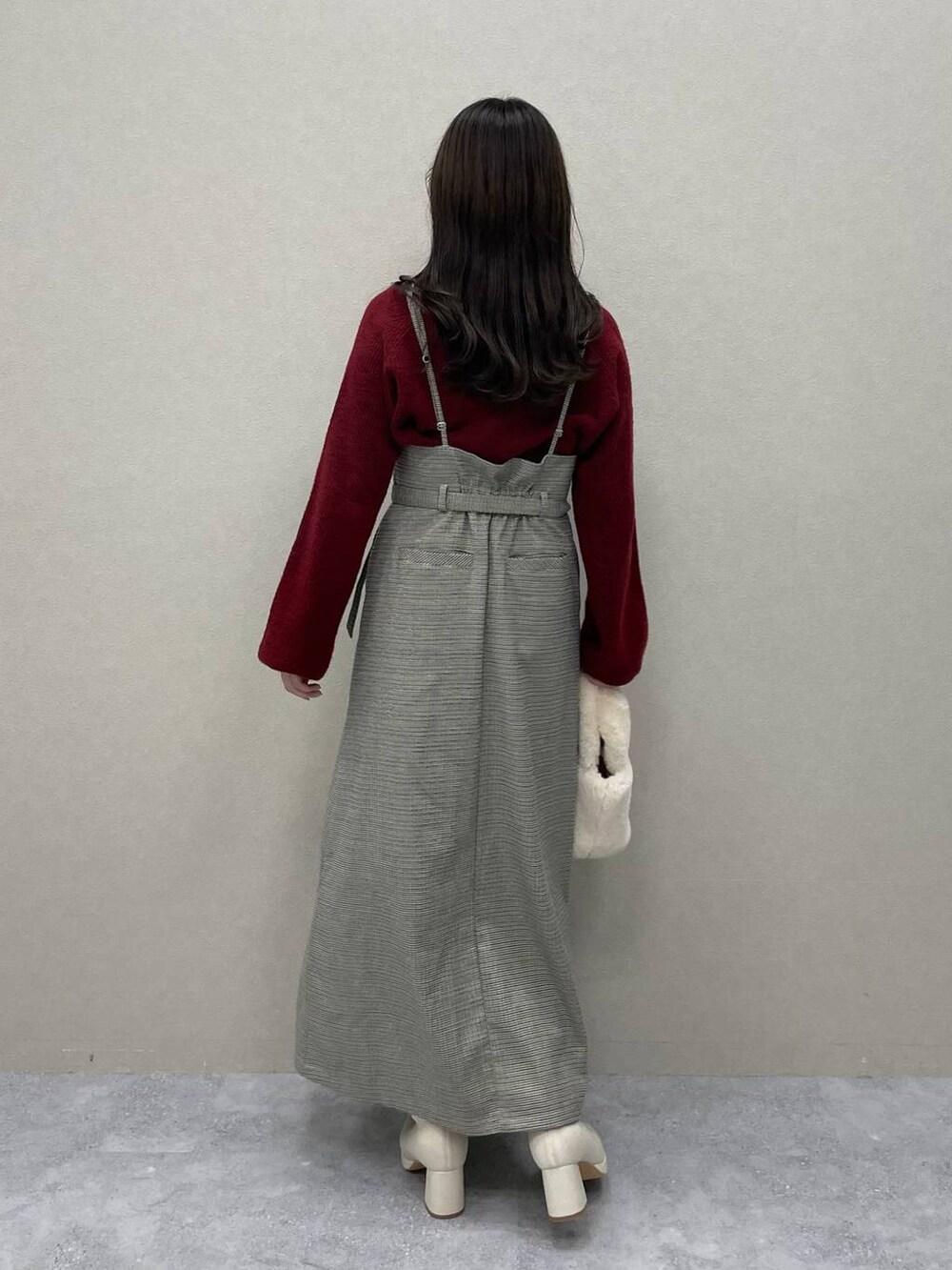 レッド系のニット/セーター、ホワイト系のブーツ、その他のスカートを着用したレディースの秋コーディネートの3枚目の写真