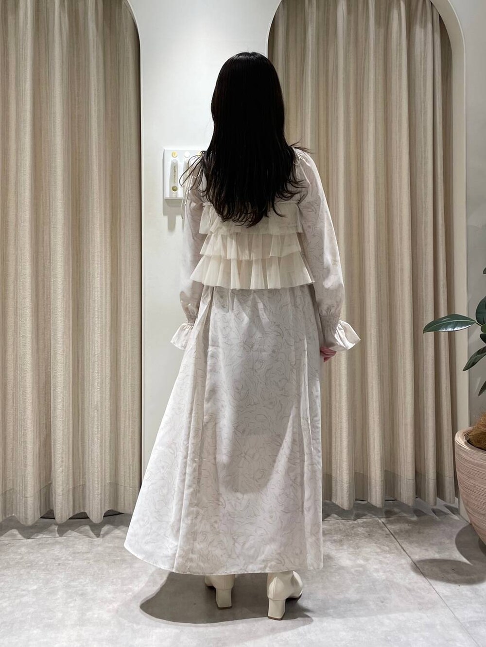 ベージュ系のワンピース、ホワイト系のシャツ/ブラウス、ホワイト系のブーツを着用したレディースの春コーディネートの2枚目の写真