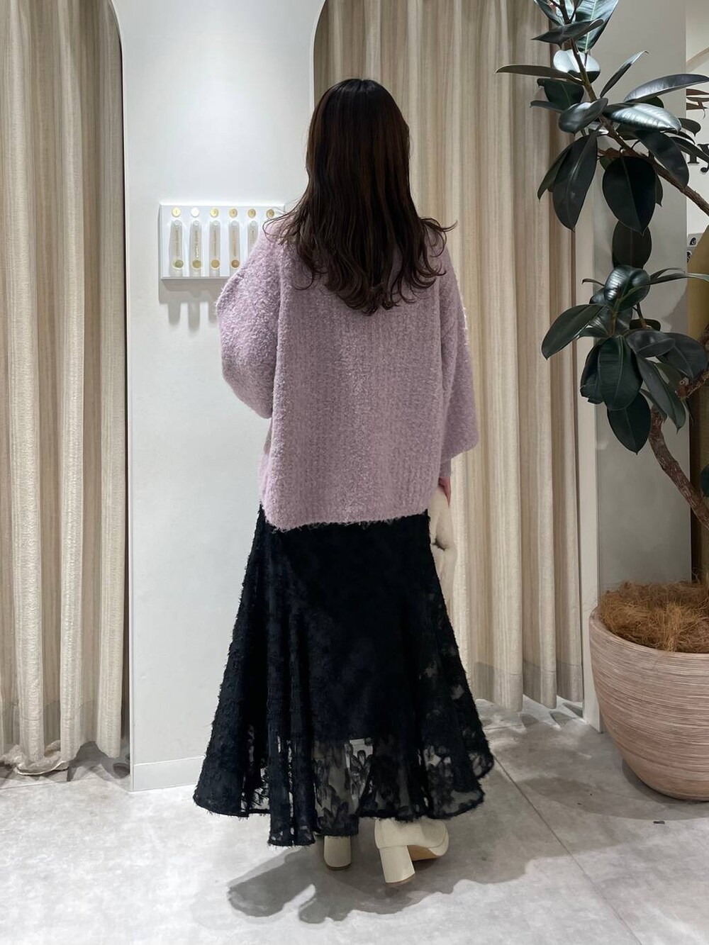 ホワイト系のブーツ、ピンク系のニット/セーター、ホワイト系のハンドバッグを着用したレディースの冬コーディネートの3枚目の写真