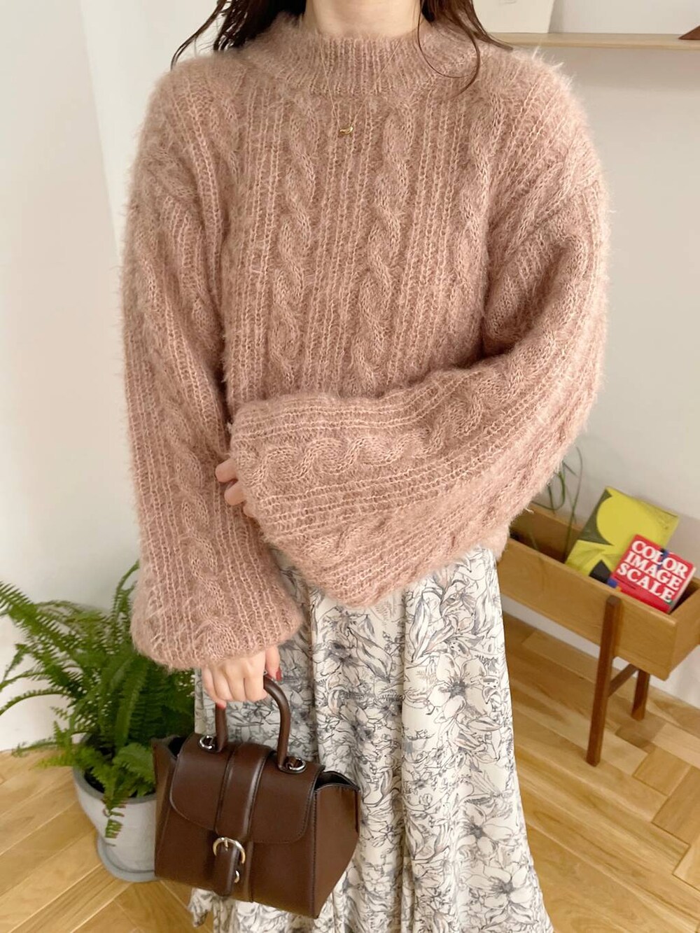 ブラック系のチェスターコート、ホワイト系のブーツ、ベージュ系のスカートを着用したレディースの秋コーディネートの6枚目の写真